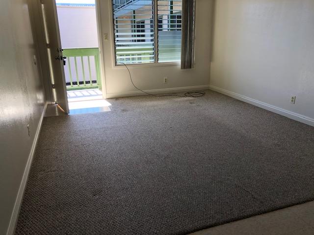 carpeted spare room featuring baseboards