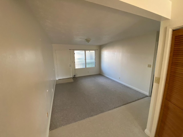 carpeted empty room featuring baseboards