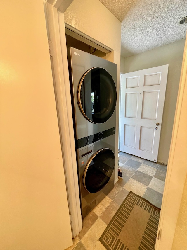 68-3883 Lua Kula St Unit 2005, Waikoloa, HI 96738 - washroom featuring stacked washing machine and dryer, a textured ceiling, and stone finish flooring