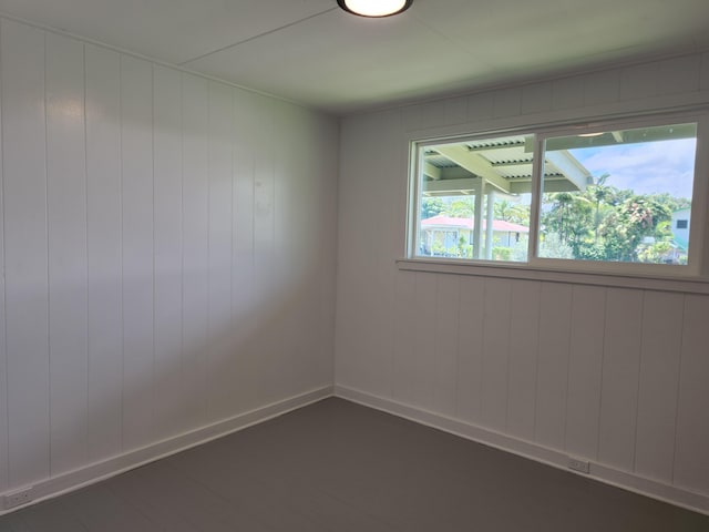 unfurnished room featuring dark wood-style floors and baseboards