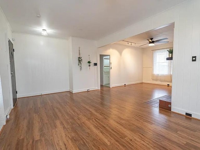 empty room with wood finished floors, baseboards, ornamental molding, and ceiling fan