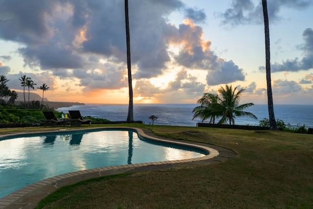2620-A Kauapea Rd, Kilauea, HI 96754 - pool at dusk featuring an outdoor pool, a water view, and a lawn