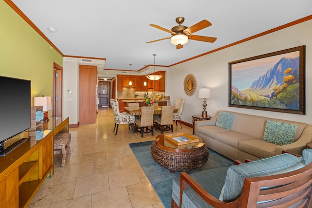 living room featuring ceiling fan, crown molding, and baseboards