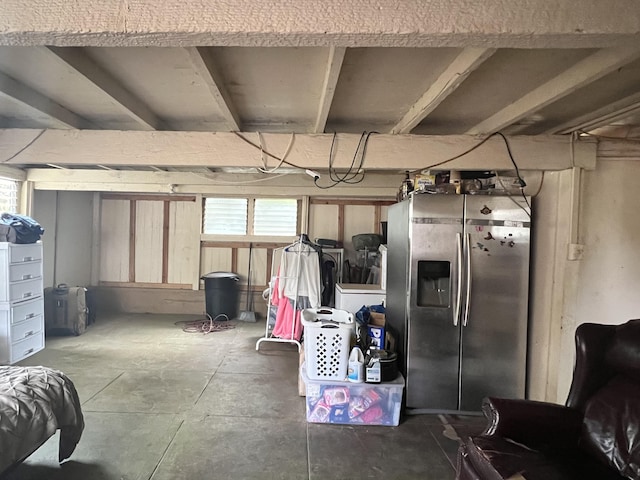 basement featuring stainless steel refrigerator with ice dispenser