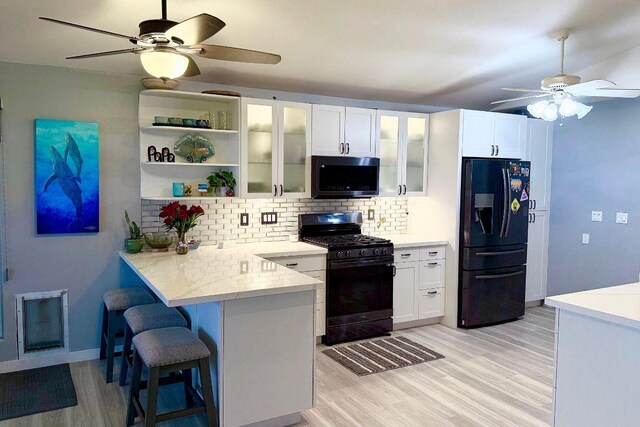 kitchen with black appliances, ceiling fan, backsplash, and white cabinetry