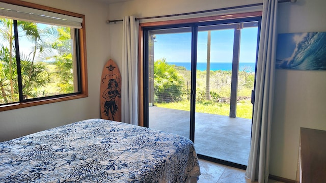 bedroom with access to exterior, multiple windows, and a water view