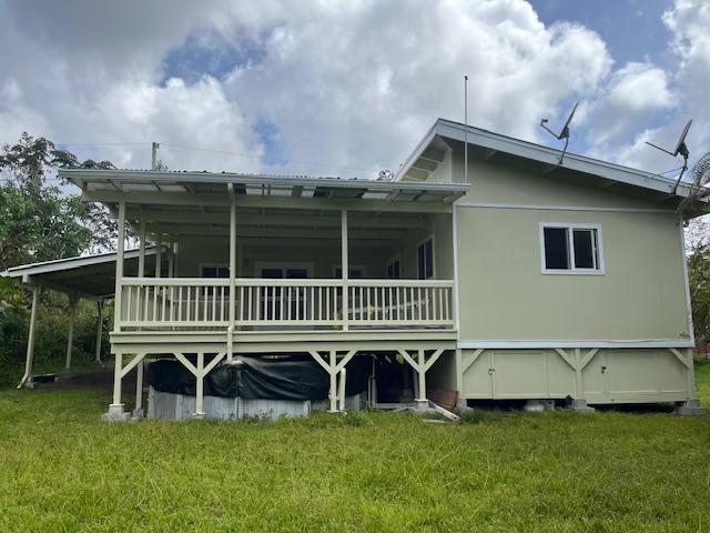 rear view of property with a lawn and a wooden deck