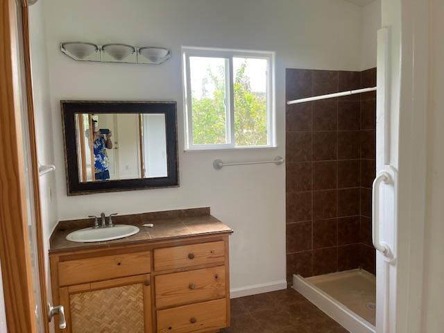 full bathroom with a stall shower and vanity