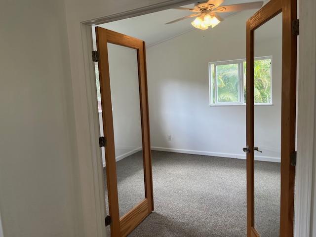 spare room featuring carpet flooring, a ceiling fan, and baseboards