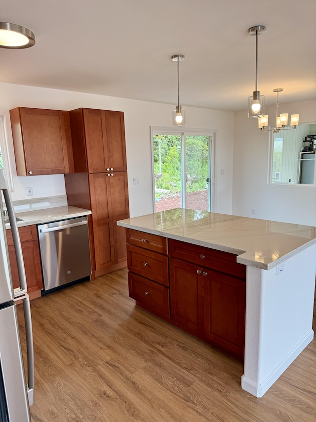 kitchen featuring stainless steel dishwasher, light wood finished floors, freestanding refrigerator, and light countertops