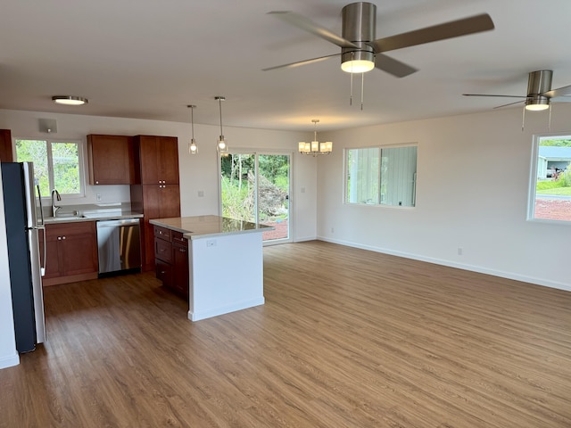 kitchen featuring appliances with stainless steel finishes, a sink, light wood-type flooring, and light countertops