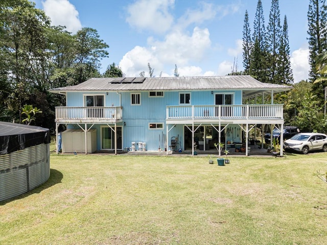 15-1519 14th Ave, Keaau, HI 96749 - back of property with roof mounted solar panels, metal roof, central air condition unit, a lawn, and a deck