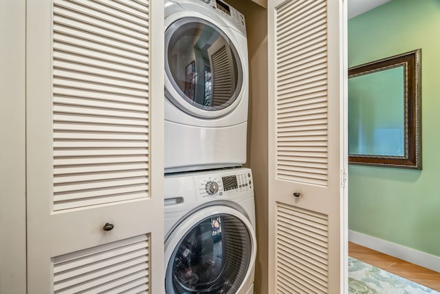 2611 Kiahuna Plantation Dr Unit 13D, Koloa, HI 96756 - laundry area featuring stacked washer and clothes dryer, baseboards, and wood finished floors
