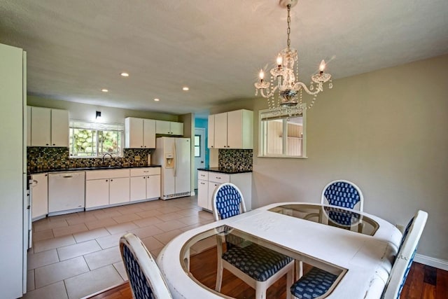 tiled dining space with an inviting chandelier and sink