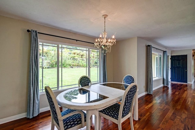 dining room with a notable chandelier, dark wood-type flooring, and a healthy amount of sunlight