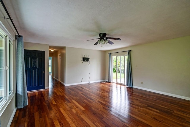 unfurnished room with a textured ceiling, ceiling fan, and dark hardwood / wood-style flooring