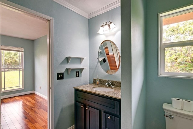 bathroom featuring toilet, vanity, wood-type flooring, and crown molding