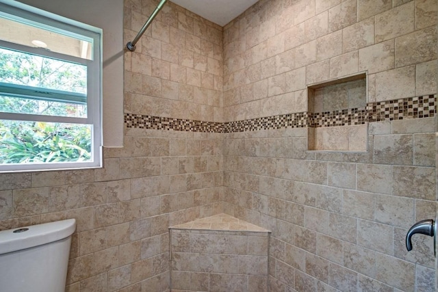 bathroom with toilet and tiled shower