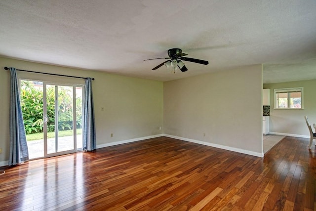 unfurnished room featuring ceiling fan, a textured ceiling, and dark wood-type flooring