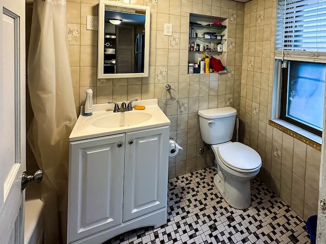 bathroom with tile patterned floors, vanity, and tile walls