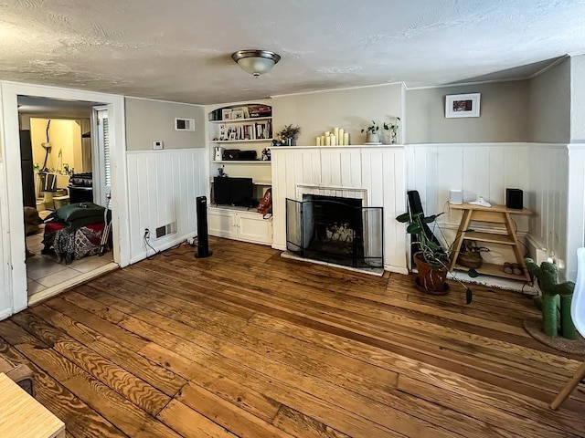 living room with wood-type flooring and a textured ceiling