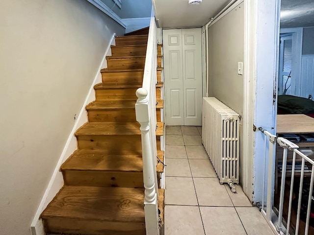 staircase with tile patterned floors and radiator heating unit