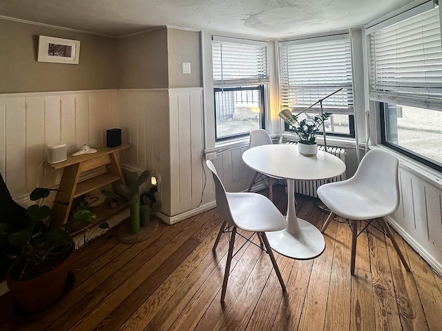 dining space featuring hardwood / wood-style flooring and a textured ceiling