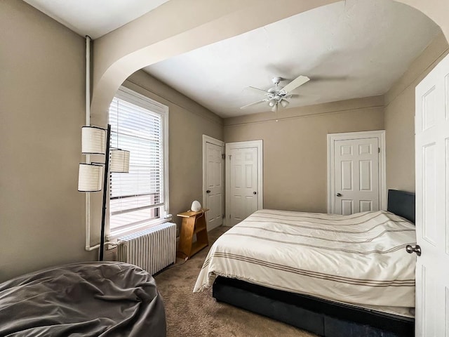 carpeted bedroom featuring ceiling fan and radiator heating unit