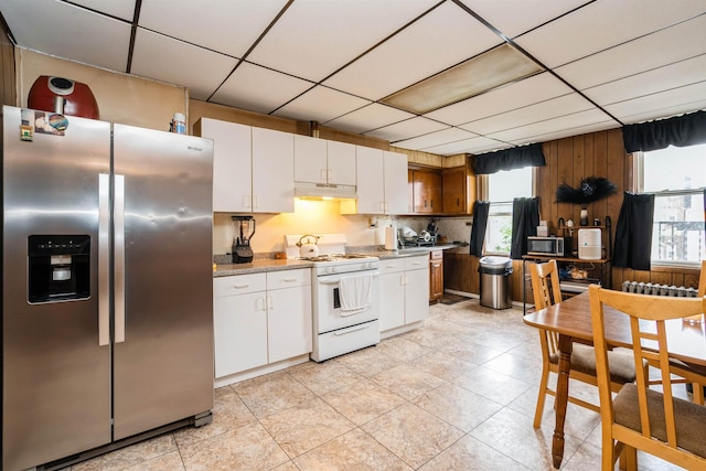 73 Laidlaw Ave, Jersey City, NJ 07306 - kitchen featuring stainless steel appliances, under cabinet range hood, plenty of natural light, a drop ceiling, and white cabinets