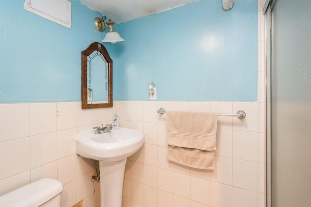 73 Laidlaw Ave, Jersey City, NJ 07306 - bathroom featuring tile walls, toilet, and wainscoting