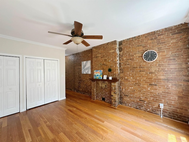 353 7th St Unit 1, Jersey City, NJ 07302 - unfurnished living room with ceiling fan, wood finished floors, and brick wall