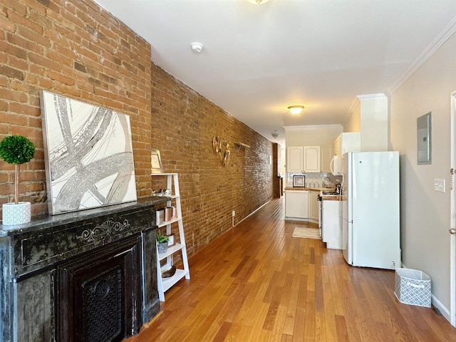 353 7th St Unit 1, Jersey City, NJ 07302 - kitchen featuring white appliances, brick wall, electric panel, light wood-style floors, and white cabinetry
