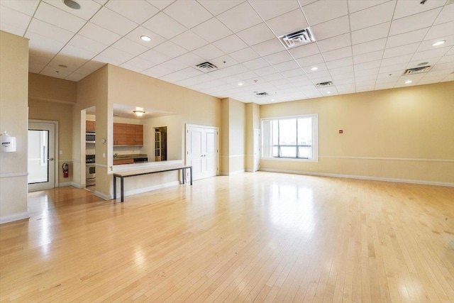 unfurnished living room featuring baseboards, visible vents, and light wood finished floors