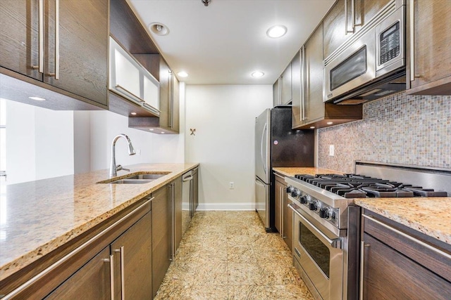 kitchen with backsplash, baseboards, recessed lighting, stainless steel appliances, and a sink