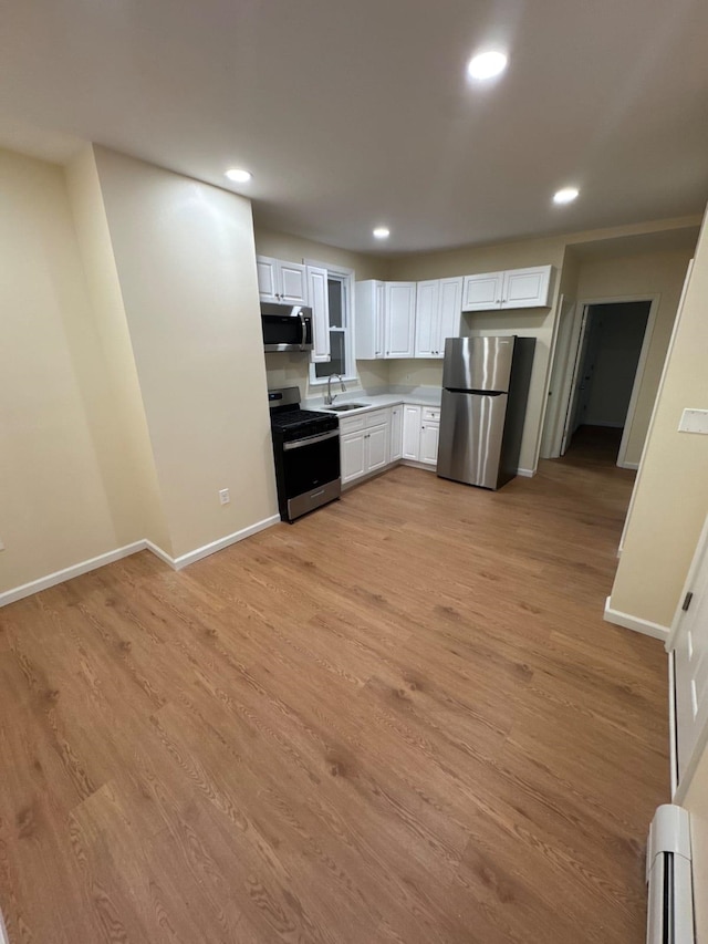 kitchen with recessed lighting, a sink, baseboards, and stainless steel appliances