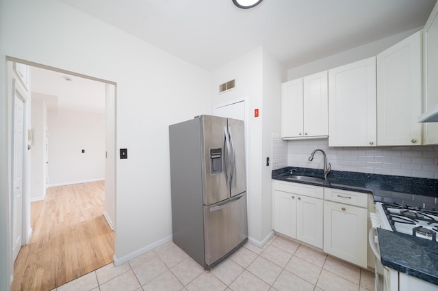 kitchen with visible vents, a sink, stainless steel fridge with ice dispenser, white cabinets, and white range with gas cooktop