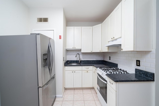 kitchen with visible vents, gas range, a sink, stainless steel fridge, and under cabinet range hood