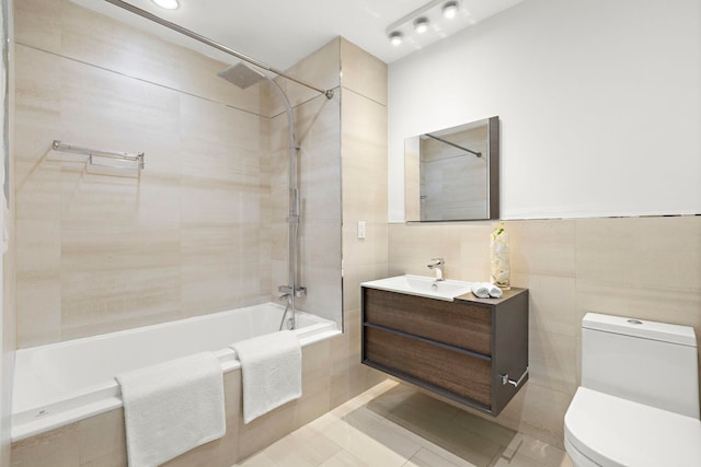 471 Monmouth St Unit 1, Jersey City, NJ 07302 - bathroom with tiled shower / bath combo, toilet, vanity, tile walls, and tile patterned floors