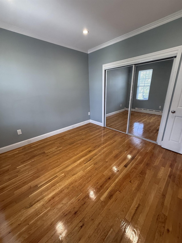 53 64th St Unit 3, West New York, NJ 07093 - unfurnished bedroom featuring crown molding, wood-type flooring, a baseboard heating unit, a closet, and recessed lighting