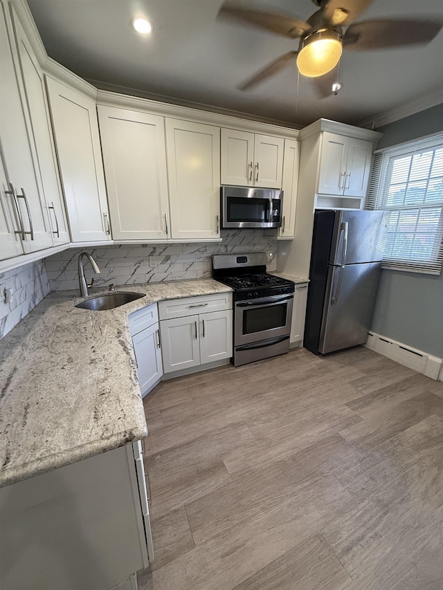 53 64th St Unit 3, West New York, NJ 07093 - kitchen featuring stainless steel appliances, a baseboard radiator, backsplash, ornamental molding, and light stone counters