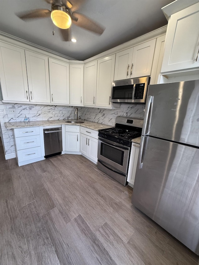 53 64th St Unit 3, West New York, NJ 07093 - kitchen with stainless steel appliances, white cabinetry, ceiling fan, light stone countertops, and decorative backsplash