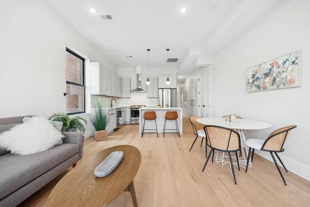 living room with light wood-type flooring and sink