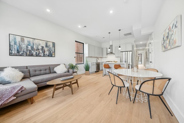 dining space featuring light wood-type flooring and sink