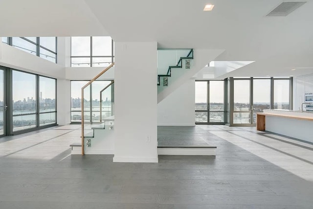 320 Adolphus Ave Unit 316, Cliffside Park, NJ 07010 - stairs with healthy amount of natural light, floor to ceiling windows, wood finished floors, a towering ceiling, and baseboards