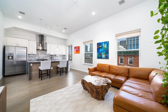 living area featuring a healthy amount of sunlight, visible vents, and light wood finished floors