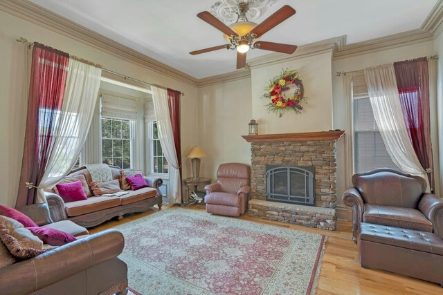 91 Sherman Pl, Jersey City, NJ 07307 - living area with ceiling fan, wood finished floors, a stone fireplace, and ornamental molding