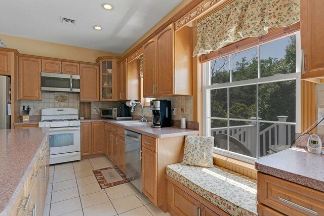 91 Sherman Pl, Jersey City, NJ 07307 - kitchen with stainless steel appliances, a sink, decorative backsplash, light tile patterned floors, and recessed lighting