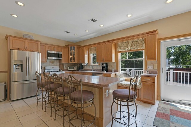 91 Sherman Pl, Jersey City, NJ 07307 - kitchen featuring stainless steel appliances, light tile patterned floors, recessed lighting, a center island, and a kitchen breakfast bar