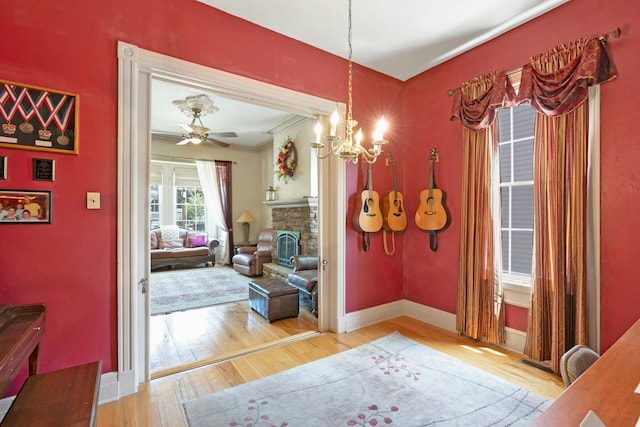 91 Sherman Pl, Jersey City, NJ 07307 - dining room featuring wood finished floors, a chandelier, baseboards, crown molding, and a fireplace
