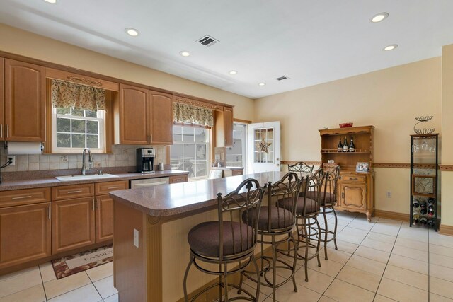 91 Sherman Pl, Jersey City, NJ 07307 - kitchen with a sink, plenty of natural light, light tile patterned floors, a kitchen bar, and recessed lighting